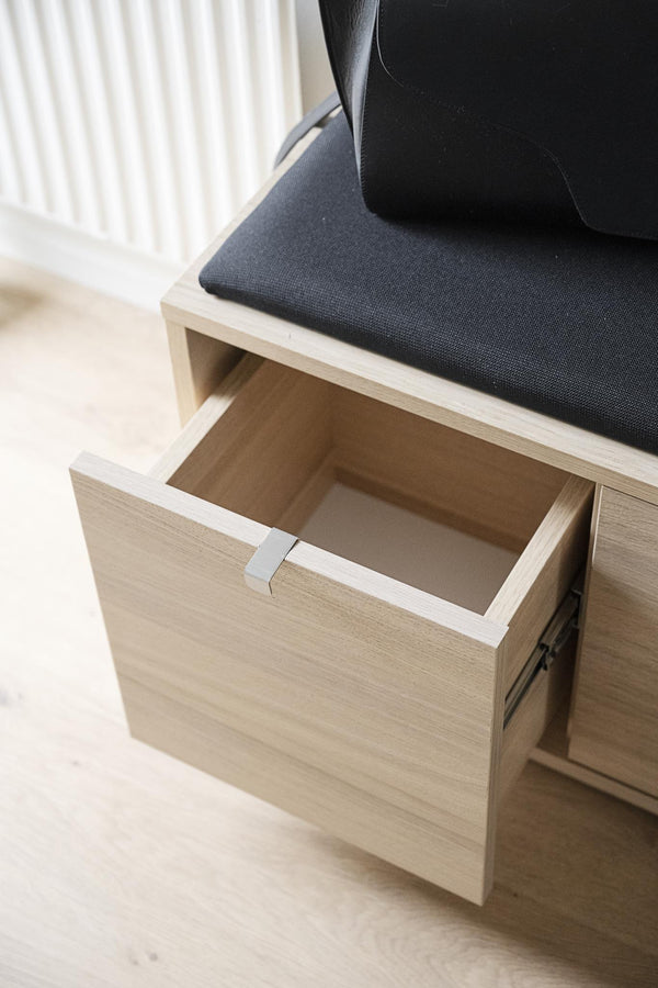 Hallbänk i ljust trä med öppen låda och svart sittdyna, modern förvaring för entré