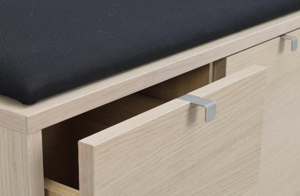 Hallbänk i ljust trä med grå handtag, öppen låda och svart sittdyna