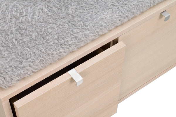 Sängbord i ljust trä med utdragbar låda och silverfärgade handtag på grå matta