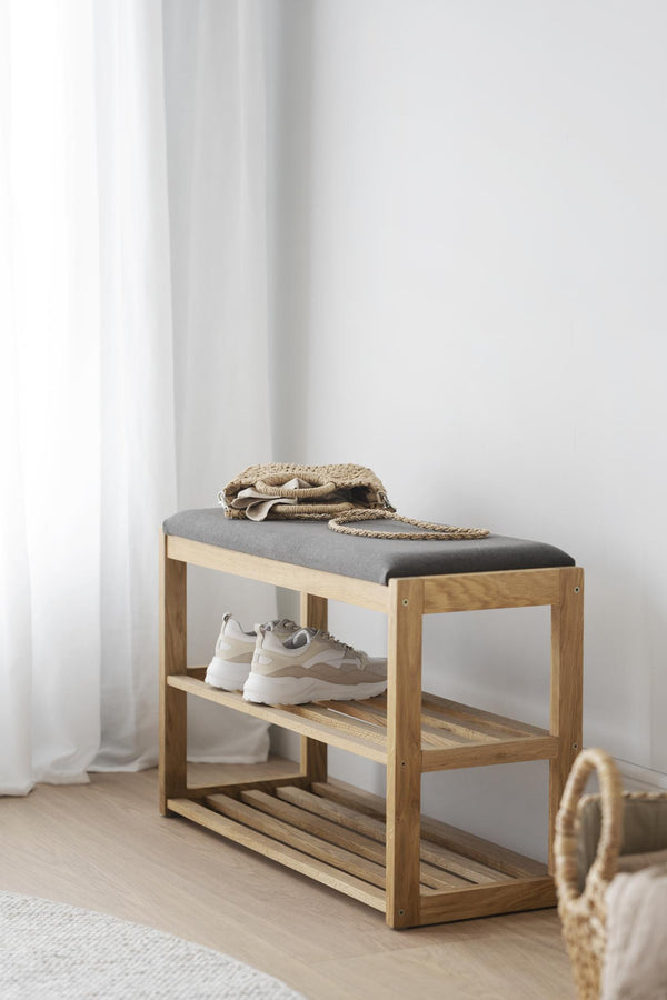 Hallbänk i ek med grå dyna och två hyllplan för skoförvaring, dekorerad med sneakers och väska