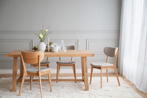 Matgrupp i ljust trä med fyra stolar och grå klädsel i modern skandinavisk stil