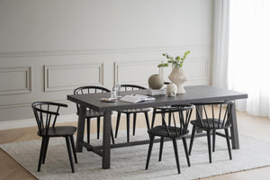 Svart matbord med sex matchande stolar i modern skandinavisk stil på ljus matta i matsal