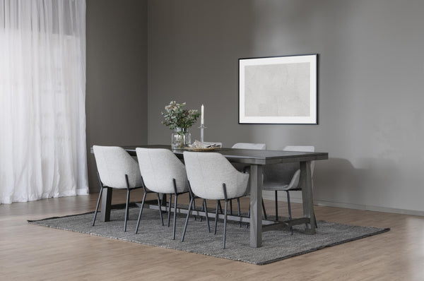Matgrupp med grått träbord och sex vita stoppade stolar på grå matta i modern matsal