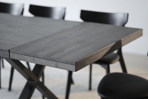 Matbord i grå ek med svarta stolar, närbild på bordsskiva och bordskant i modern skandinavisk design