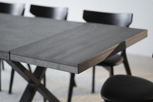 Matbord i grå ek med svarta stolar, närbild på bordsskiva och bordskant i modern skandinavisk design