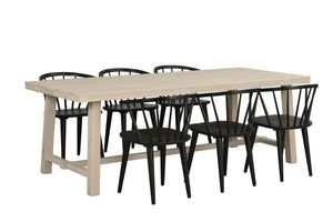 Matgrupp med ljust trä bord och sex svarta pinnstolar i skandinavisk design