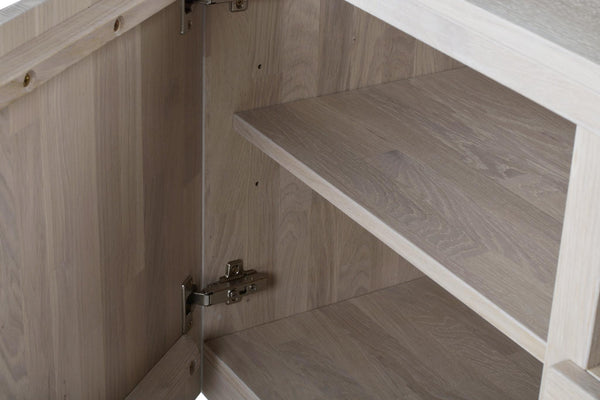 Skåpinteriör med ljusgrå trästruktur, två hyllplan och synligt gångjärn i metall