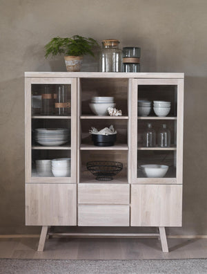 Vitrinskåp i ljust trä med glashyllor, displayhyllor och lådor, inrett med porslin och köksförvaring