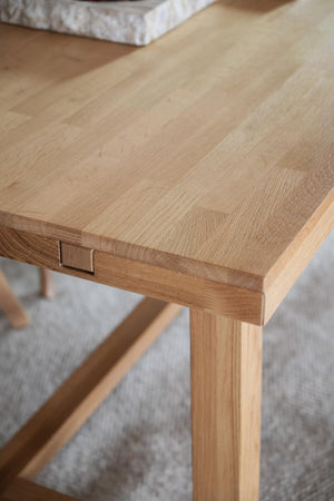 Närbild på träbordsskiva i ek med synlig träfibrer och snickardetalj vid bordskanten