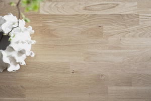 Ljust trägolv i ek med vita blommor i kruka, naturlig trästruktur och moderna plank