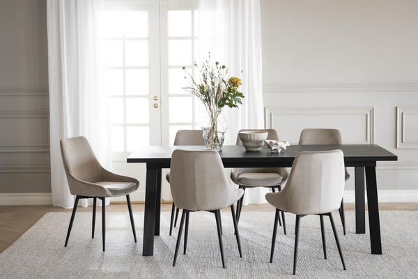 Matgrupp med svart bord och sex grå stolar i elegant matsal med ljusinsläpp från fönsterdörr