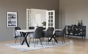 Matgrupp med vitt bord, grå stolar och svart skåp i modern matsal med ljust trägolv