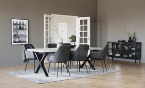 Matgrupp med vit bord, grå stolar och svart skåp i modern skandinavisk matsal med trägolv