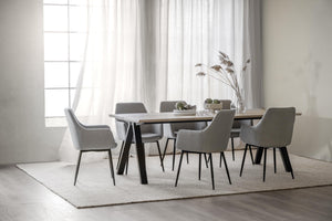 Matgrupp med grå stolar och bord i ljus modern matsal med vita gardiner