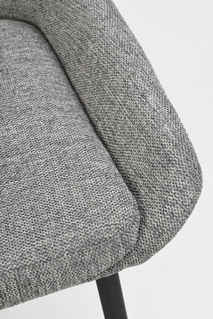 Närbild på grå stoppad stolsdyna med melerad textilklädsel och svart metallben