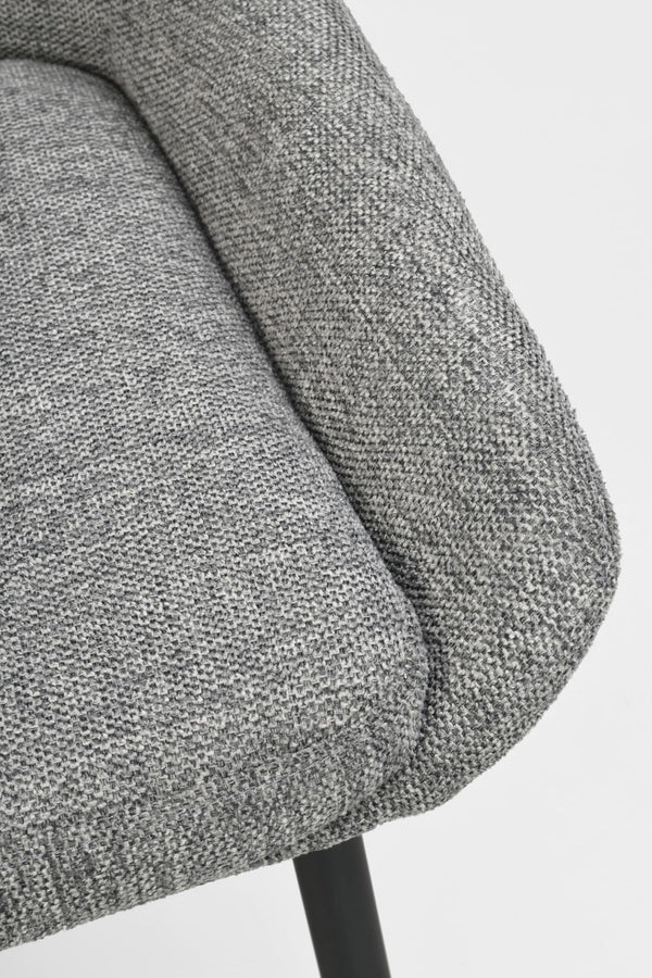 Närbild på grå stoppad stolsdyna med melerad textilklädsel och svart metallben