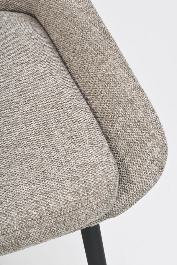 Närbild på stols armstöd och sits i beige melerat tyg med svarta metallben