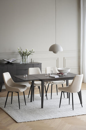 Matgrupp med grått bord och beige stolar i modern matsal med vit väggpanel och pendant lampa