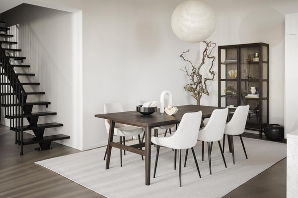 Modern matplats med mörkt matbord, vita stolar och vitrinskåp i skandinavisk stil