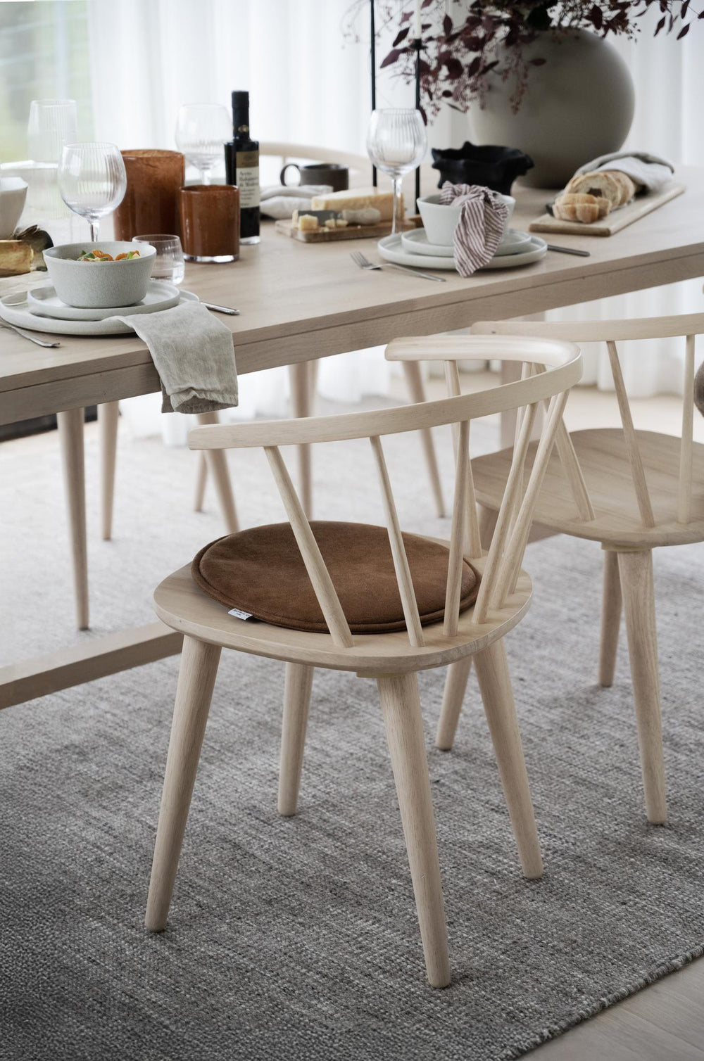 Rund brun hundbädd i mjukt tyg med MUOVO-etikett, oval form och platt design