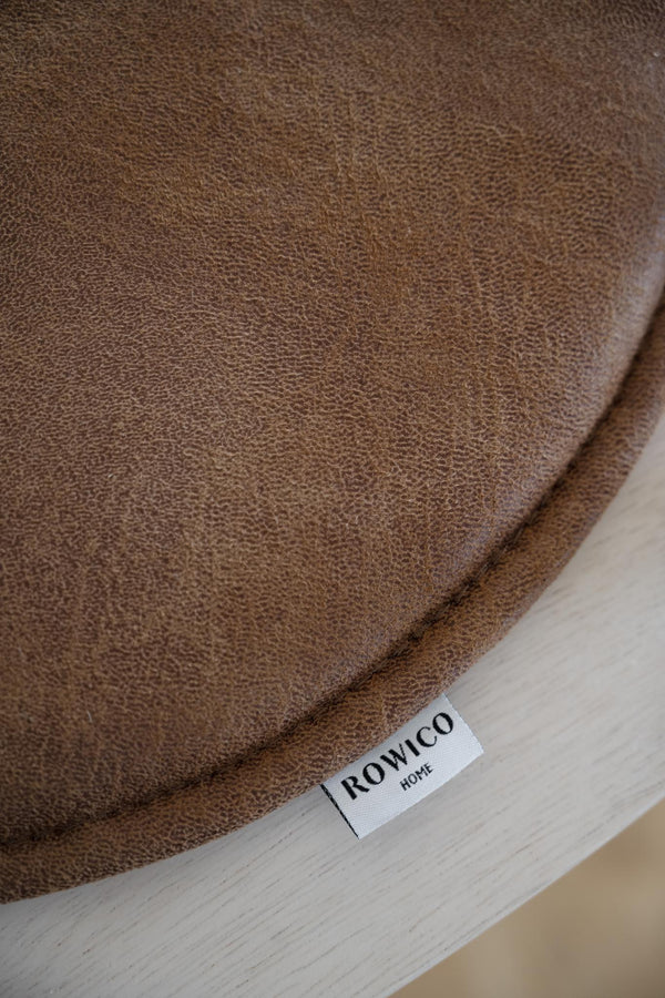 Brun frotté handduk från Rowico Home med vävd textur och vit etikett på ljust trägolv