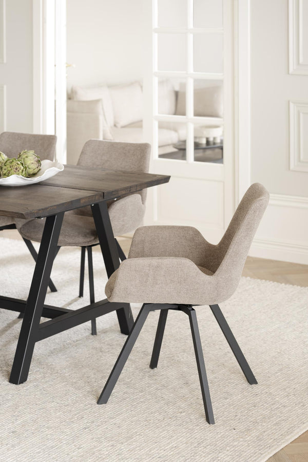 Grå stoppad matstol med svarta metallben vid matbord i modern skandinavisk stil