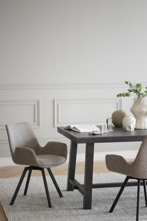 Matbord i mörkbejsat trä med två bruna stolar med armstöd och svarta ben i modern skandinavisk stil