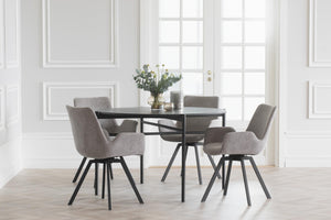 Matgrupp med runt svart bord och fyra grå stolar med svarta ben i ljust matrum
