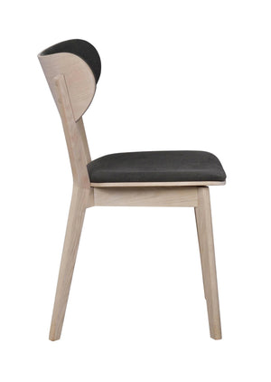 Matstol i ljust trä med svart sits och rygg, sidovy av modern skandinavisk design