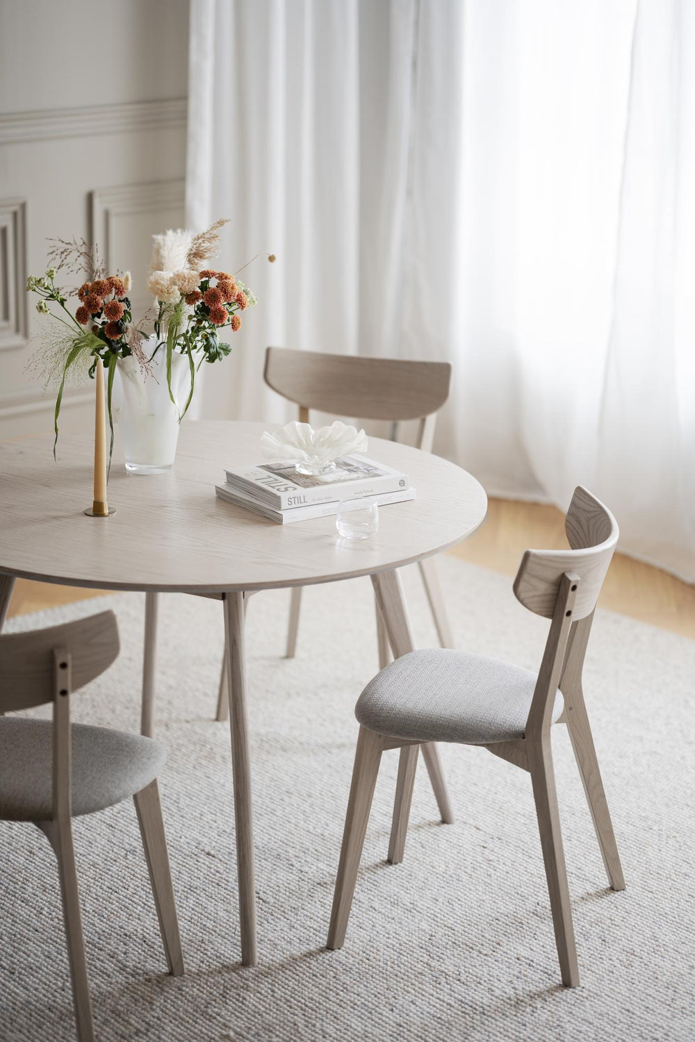 Stol i ljust trä med grå stoppad sits och bred rygg i skandinavisk design