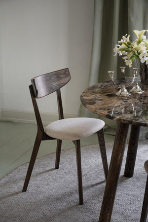 Matbord i marmor med mörkbrun träram och matchande stol med beige klädsel i elegant matsal