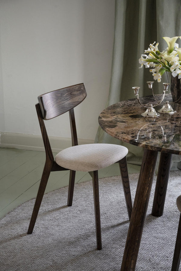 Matbord i marmor med mörkbrun träram och matchande stol med beige klädsel i elegant matsal