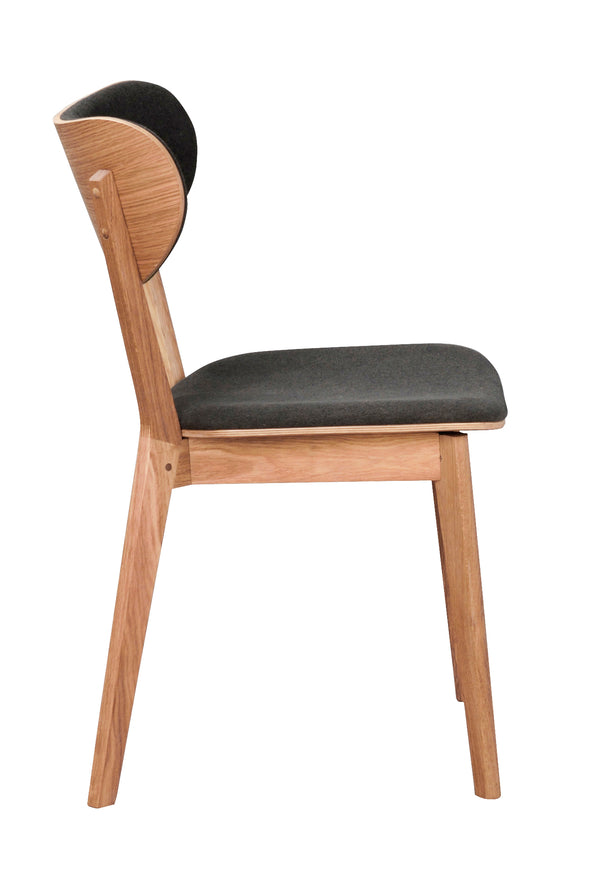 Matstol i ek med svart stoppad sits och rygg, sidovy som visar träkonstruktion och design