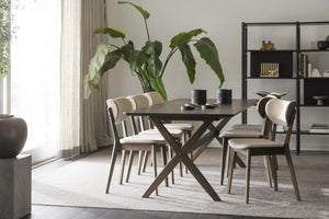 Matgrupp med mörkt träbord och fyra stolar i modern skandinavisk design med ljusa dynor