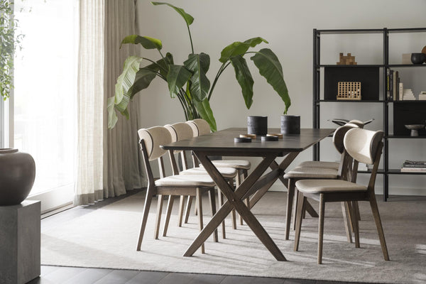 Matgrupp med mörkt träbord och fyra stolar i modern skandinavisk design med ljusa dynor