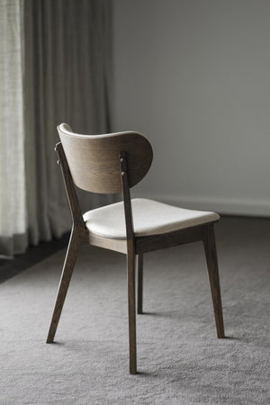 Matstol i mörkbejsat trä med stoppad sits i ljust tyg, elegant ryggstöd med rundad form