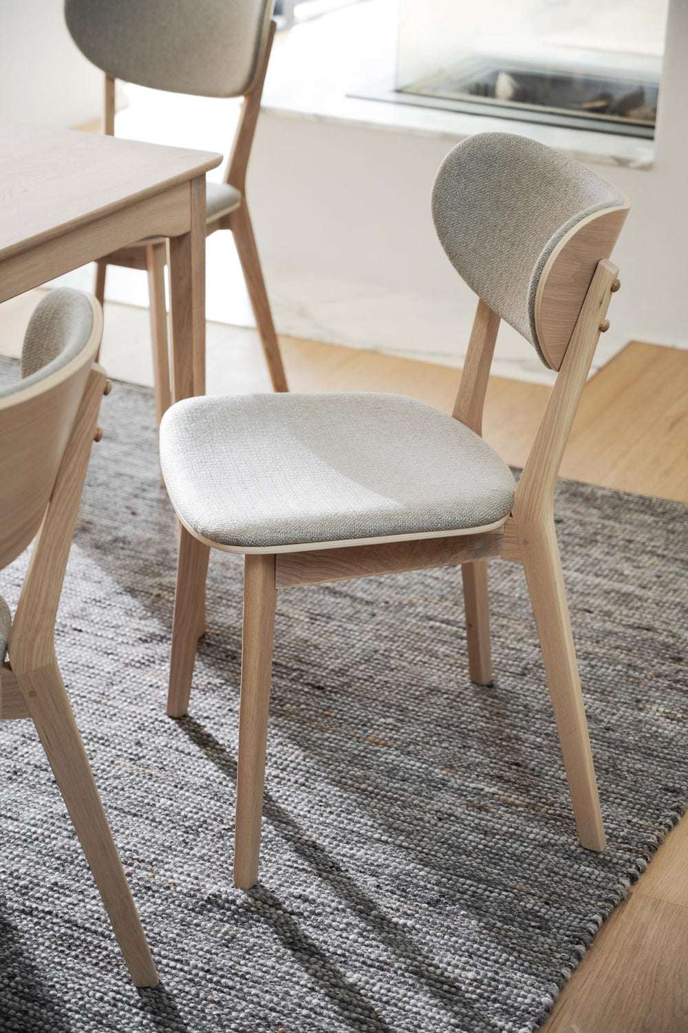 Stoppad matstol i ljust trä med beige tyg, modern skandinavisk design