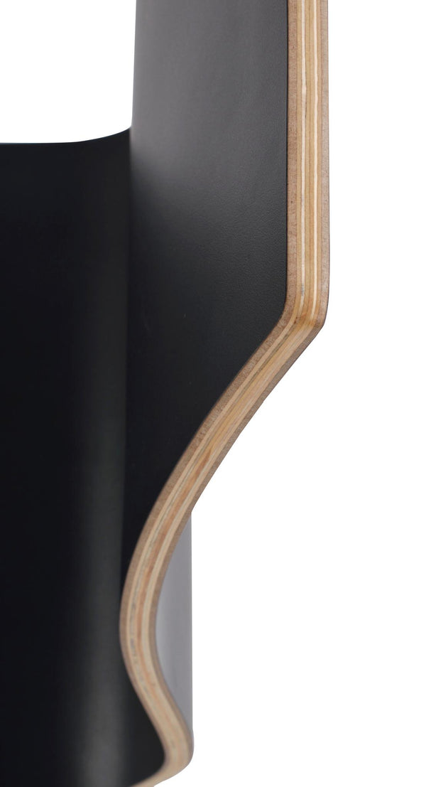 Närbild på svart lamineratskiva med synliga plywoodlager i kanten, böjd form