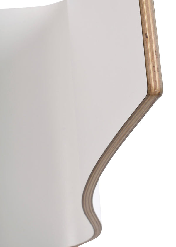 Närbild på vit laminatskiva med synlig plywoodkant i naturligt trä med böjd form