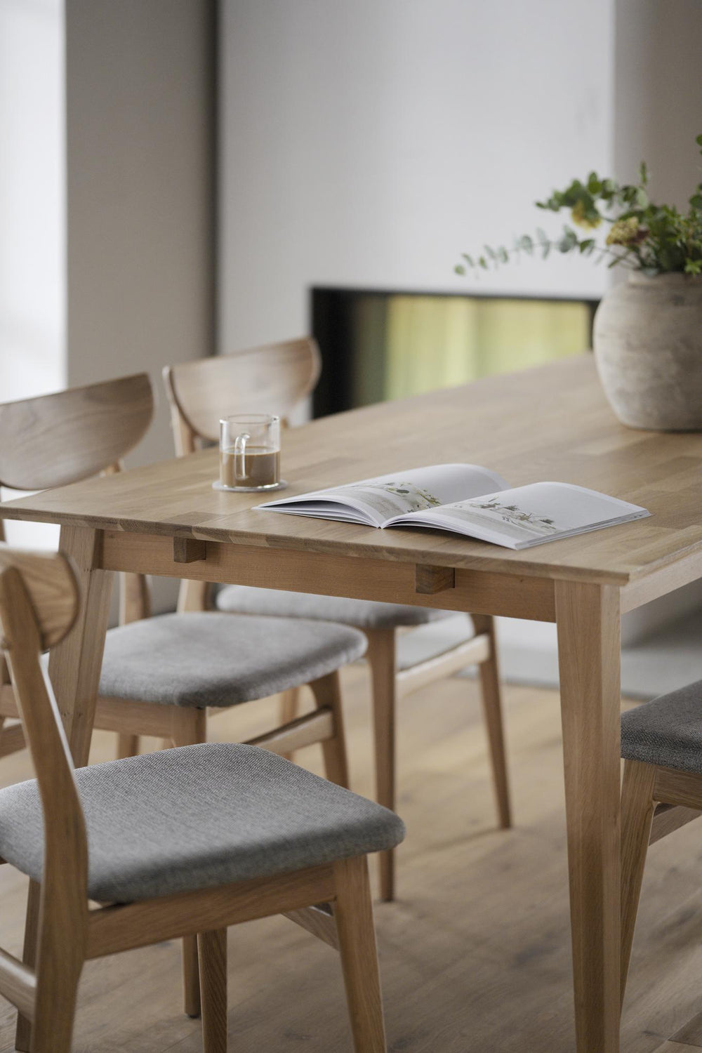 Utdragbart matbord i ek med synlig förlängningsskiva och träben