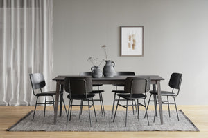 Matgrupp med svart träbord och sex matchande stolar i modern skandinavisk design på grå matta