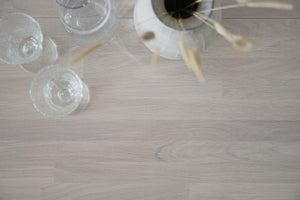 Champagneglas och champagneflaska på ljust träbord, ovanifrån sett