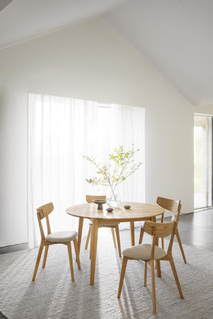 Matgrupp i ek med runt bord och fyra stolar med beige klädsel i ljust skandinaviskt matrum