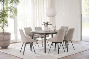 Rund matgrupp med sex beige stoppade stolar i ljus skandinavisk matsal med stora fönster