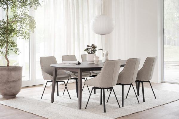Matgrupp med ovalt bord och sex grå stolar i modernt hem med ljusa toner