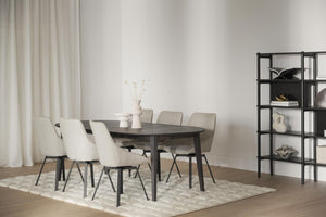 Matgrupp med ovalt svart bord och beige stolar på matta i modernt matrum med hylla