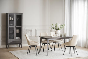 Matbord i mörkgrått trä med fyra beige stolar och vitrinskåp i modern matsal med ljust inredning