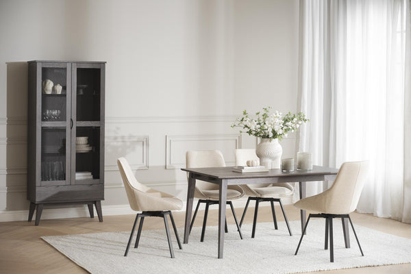 Matbord i mörkgrått trä med fyra beige stolar och vitrinskåp i modern matsal med ljust inredning