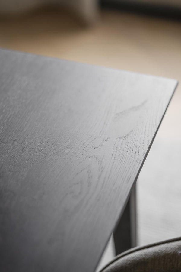 Närbild av ljusgrå bordsskiva med trästruktur och elegant kant