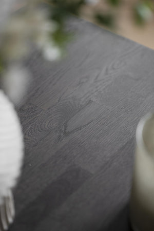 Närbild av mörkgrå träbord med synlig ådringsmönster och trästruktur